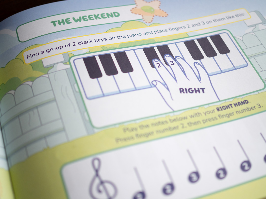 Page from Bluey: First Ever Piano Book showing a piano activity using right-hand fingers 2 and 3 on groups of three black keys.